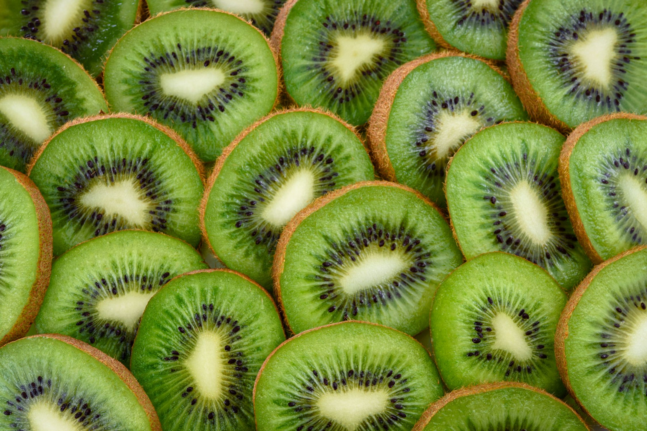 Sliced kiwi fruits showing their bright green flesh and tiny black seeds